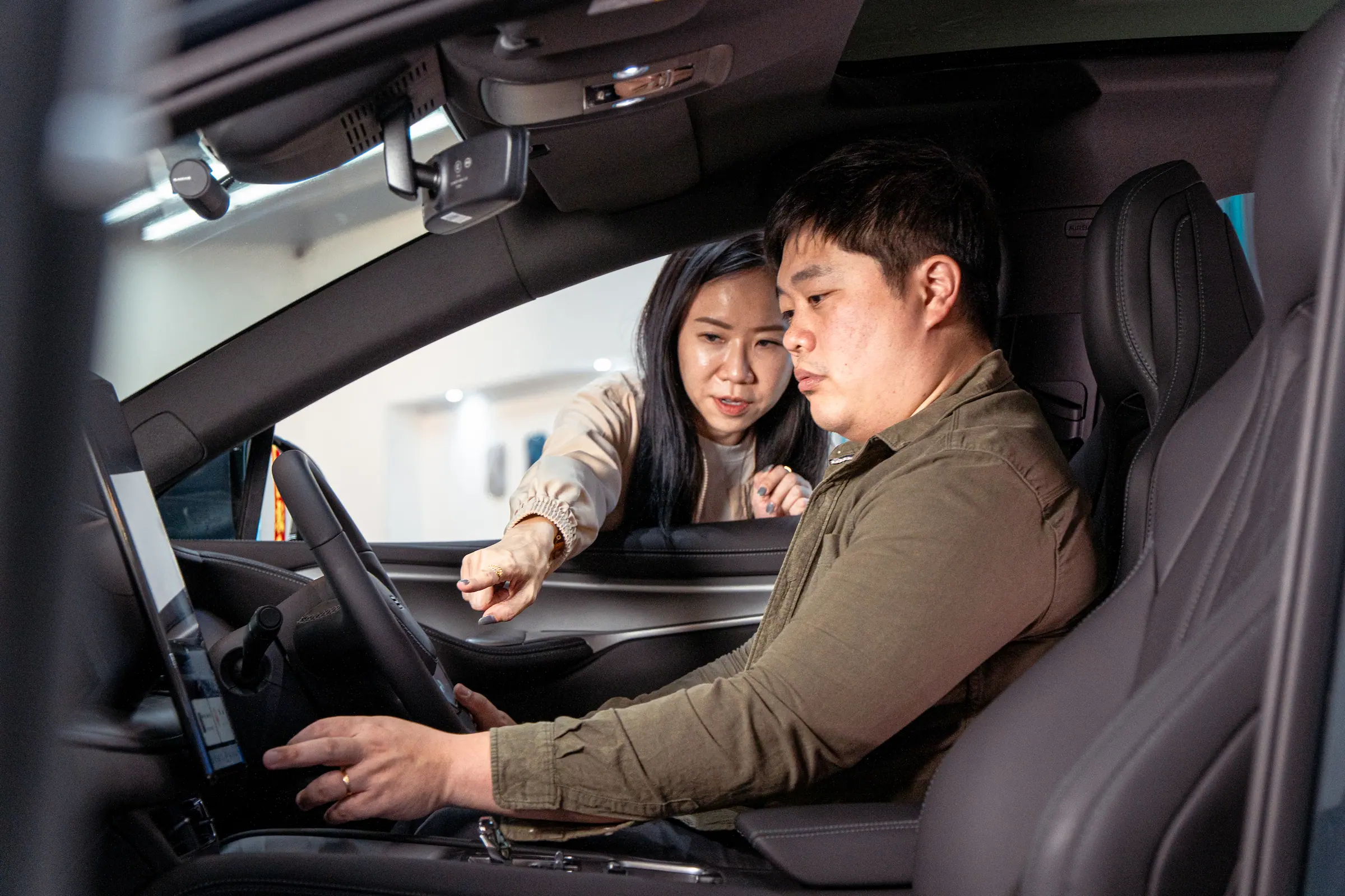 Two people exploring the interior of a BYD at Suntec City
